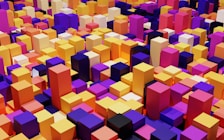 A vibrant and colorful collection of 3D blocks arranged in a cityscape-like formation. The blocks vary in height and are organized in a dense pattern, featuring a variety of bright and saturated colors including yellow, magenta, orange, and purple.