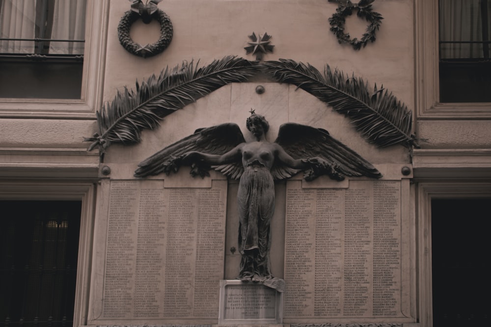 a statue of an angel on the side of a building