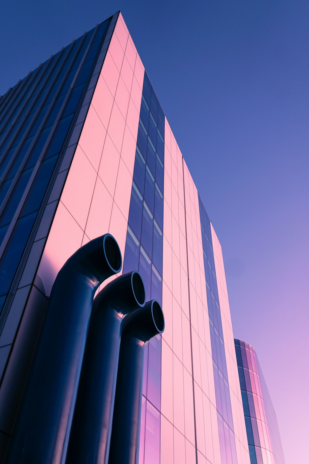 a tall building with a bunch of pipes in front of it