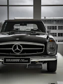 Elegant black antique car displayed in a modern showroom.