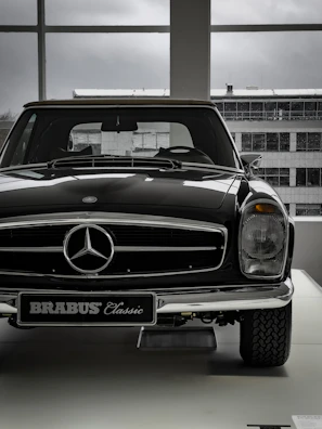 Elegant black antique car displayed in a modern showroom.