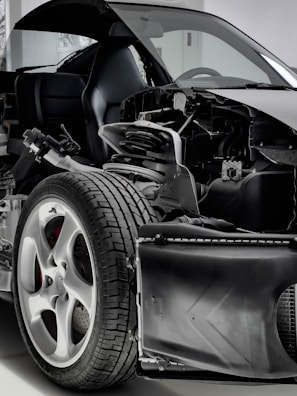 A detailed view of a car with its exterior partially removed, exposing the internal components. The image focuses on the wheel, suspension, and other mechanical parts, highlighting the intricate design and engineering.