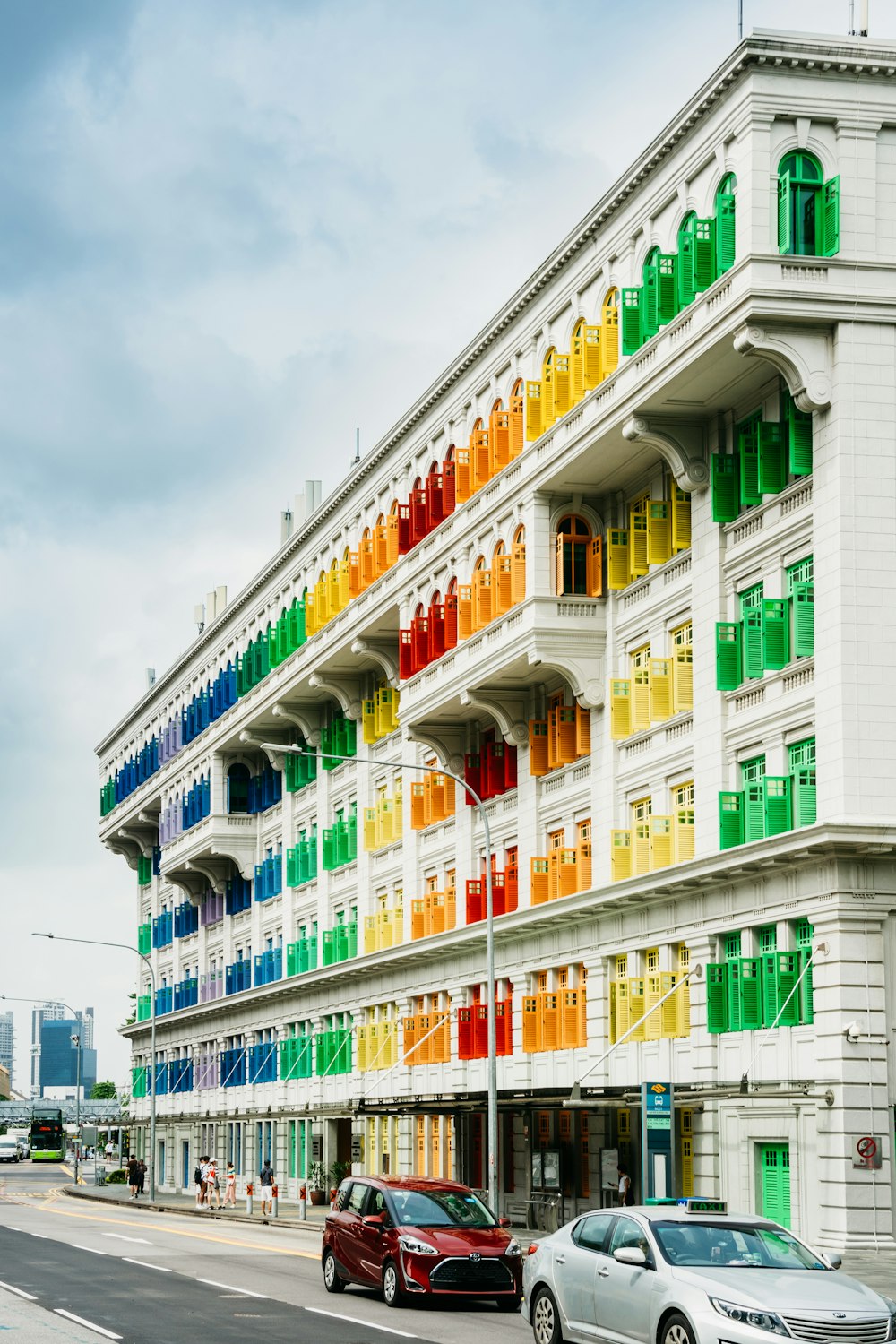 um edifício multicolorido com carros estacionados em frente a ele