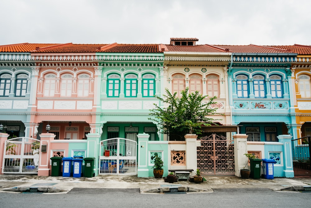 a row of multicolored buildings with a tree in front of them