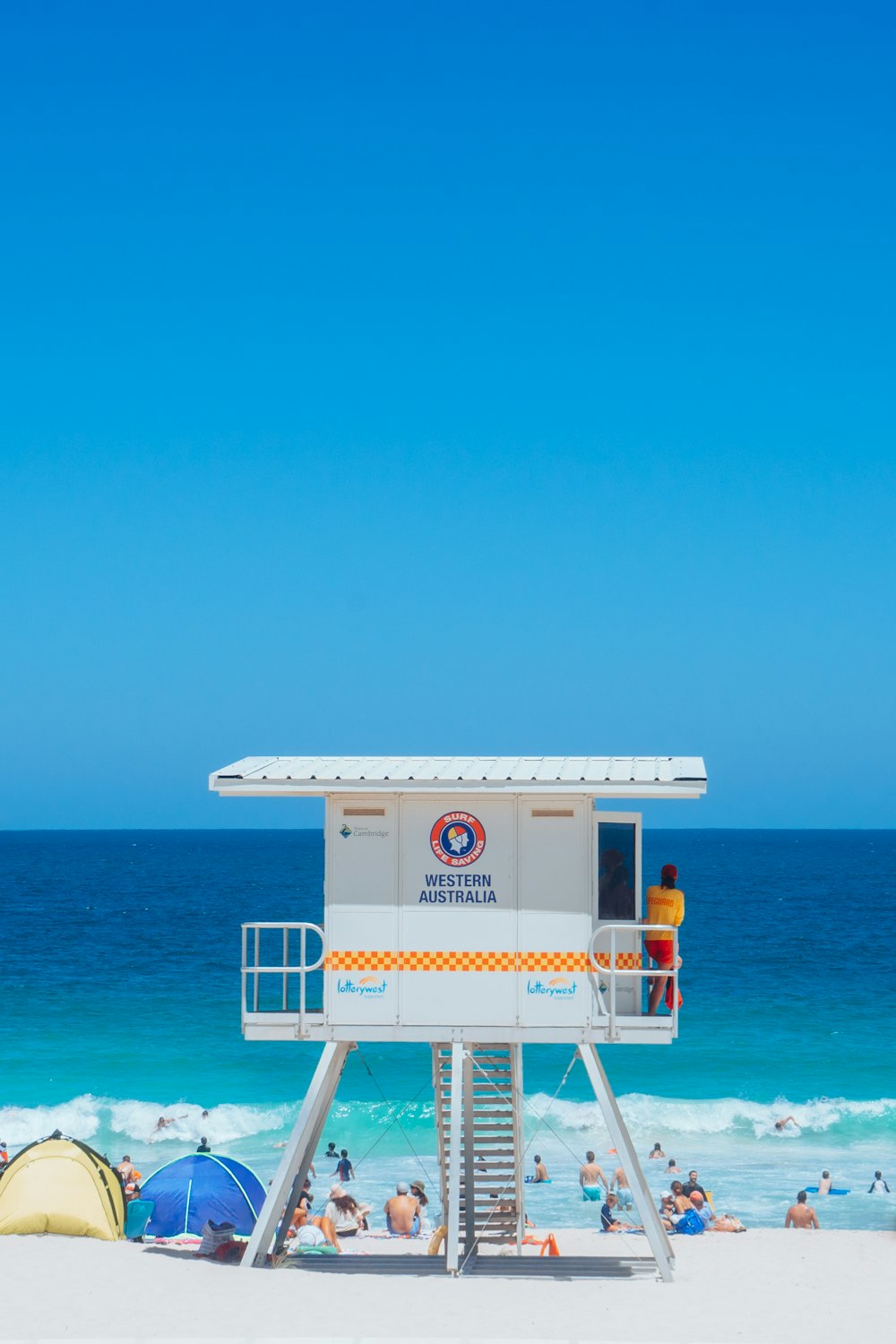 a lifeguard stand on the beach with people in the water
