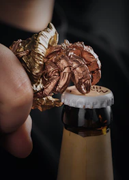 Close-up of the odpirač can opener in use at a busy pizzeria kitchen.