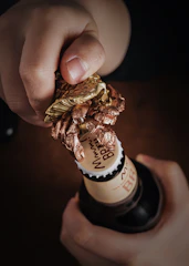 Close-up of a sleek personalized bottle opener with a brushed metal finish and engraved initials.