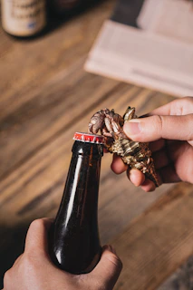 Hands using the odpirač can opener effortlessly on a large can in a bustling pizzeria kitchen.