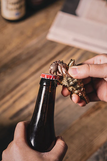 Close-up of a sleek personalized bottle opener engraved with a custom name on a wooden table.