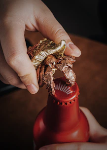 A hand holding a personalized bottle opener attached to a keychain, highlighting its compact and stylish design.