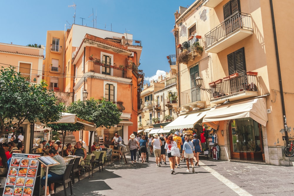 Un gruppo di persone che camminano lungo una strada accanto a edifici alti