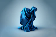 A sleek slate blue fabric sample draped over minimalist tools arranged with precision.