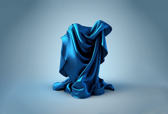 Luxurious silk scarf in deep blue tones draped gracefully over a white chair.
