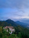 Evening view of the villa glowing warmly against the mountain backdrop.