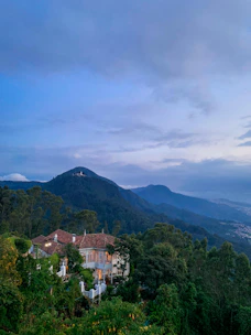 A serene villa nestled among lush green hills under a soft morning light.