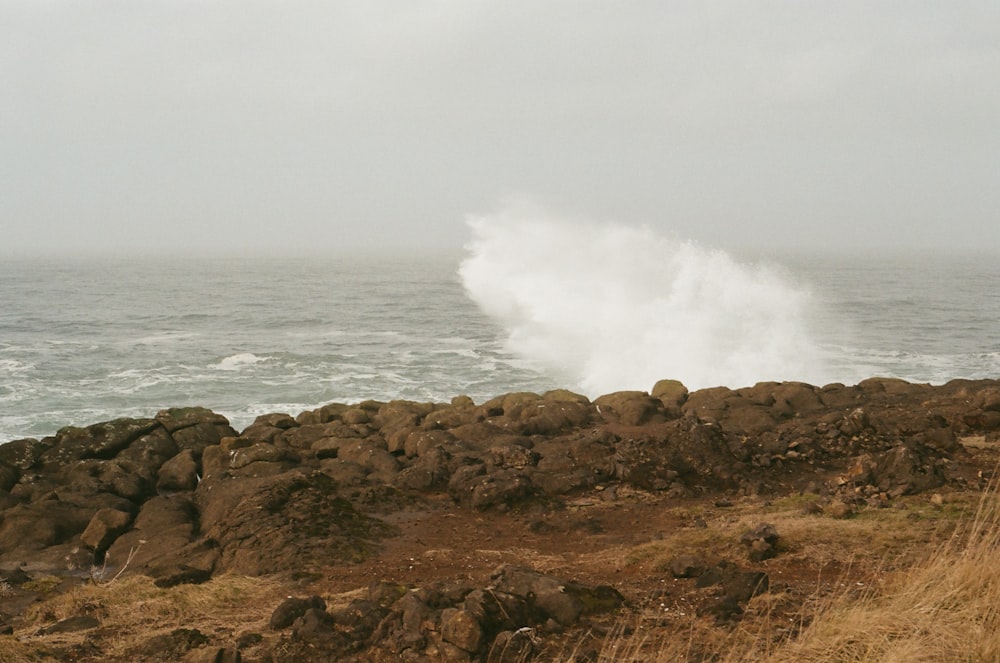 uma grande onda batendo sobre uma costa rochosa