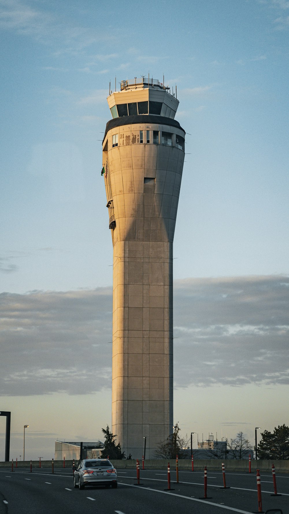 a car driving down a road next to a tall tower