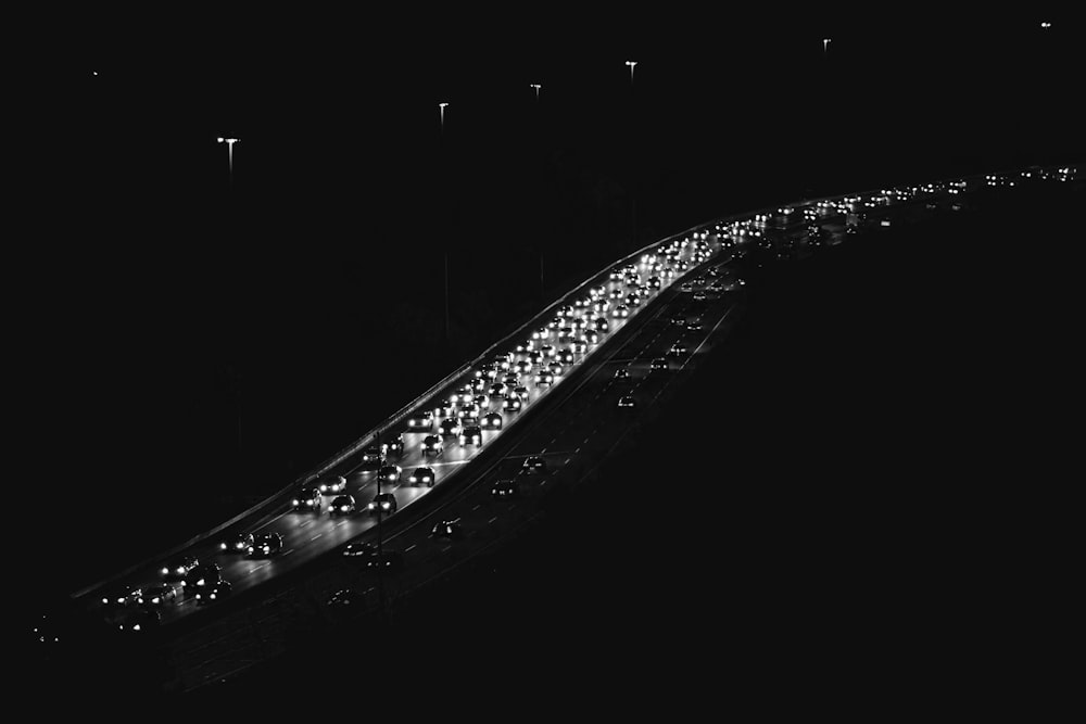 a long line of cars driving down a street at night