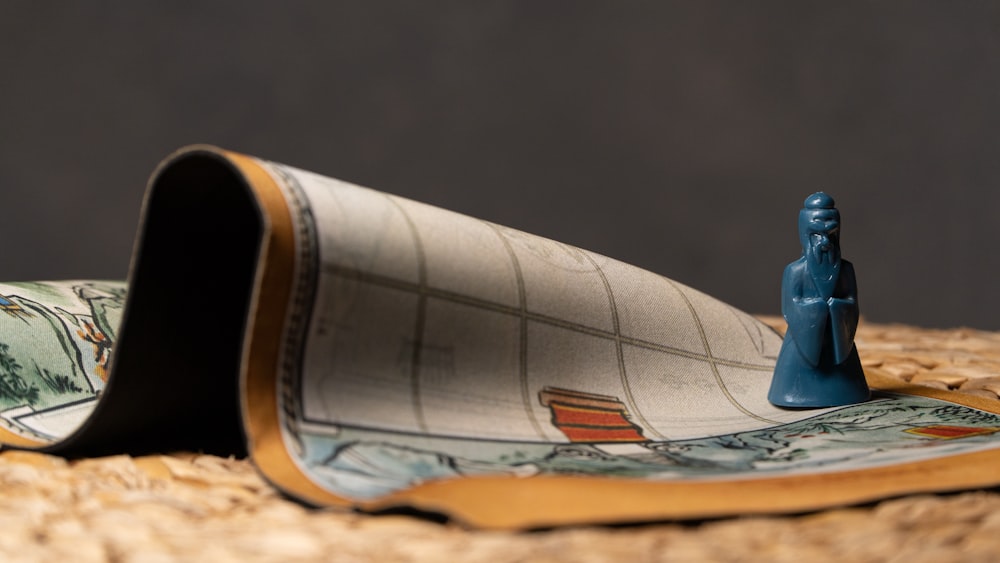 a small blue figurine sitting on top of a rug