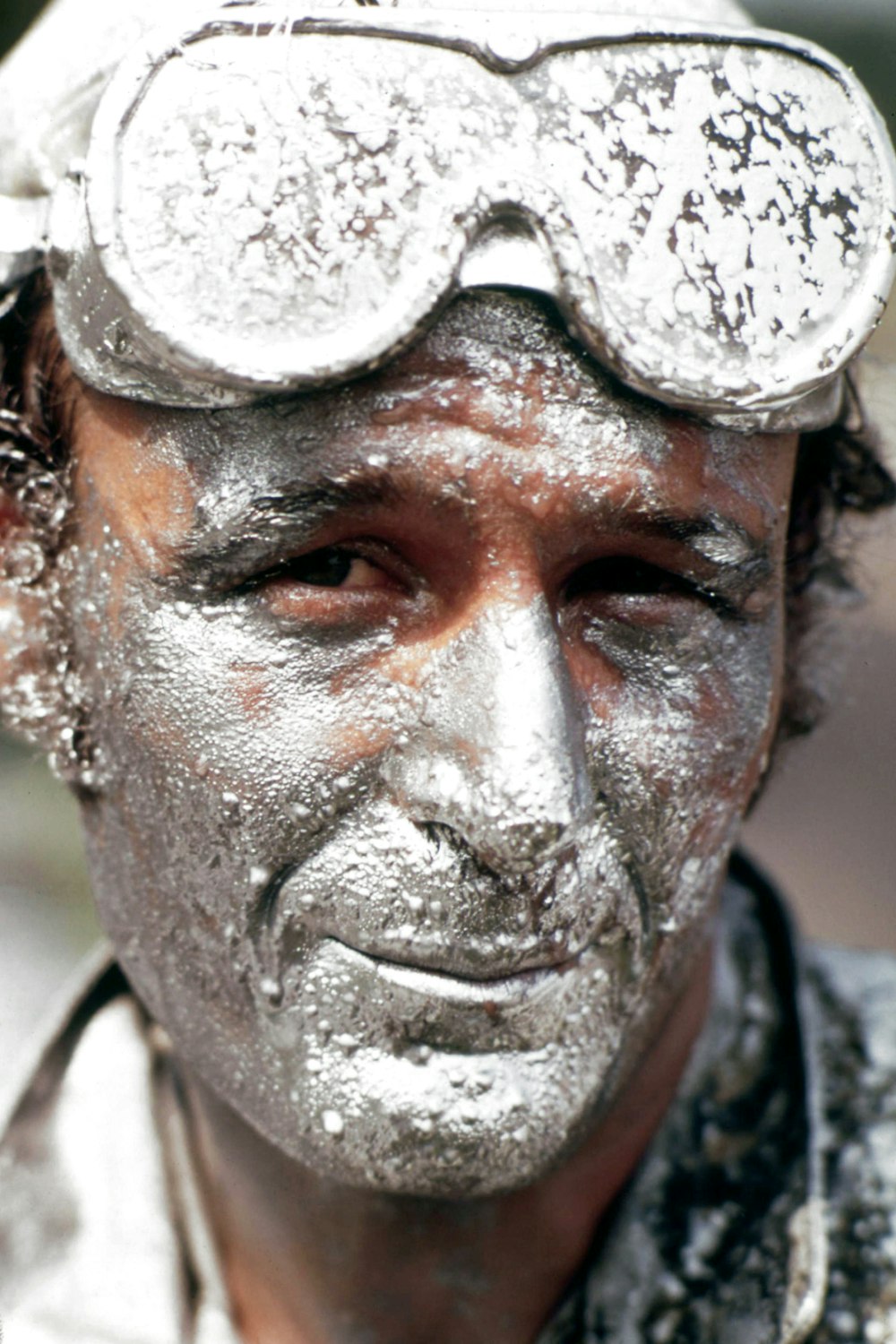 a man covered in powder with goggles on his head