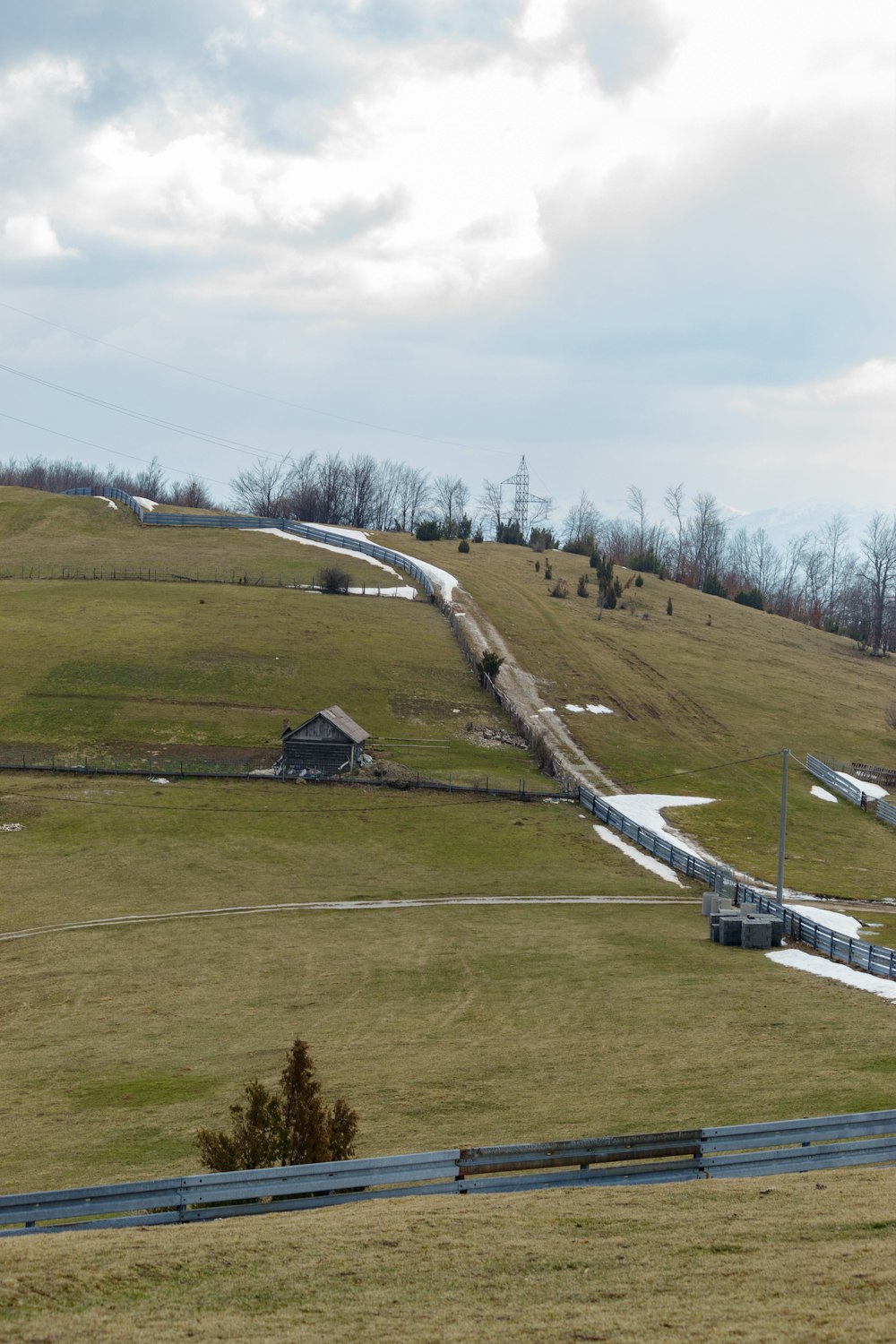 a grassy field with a hill in the background