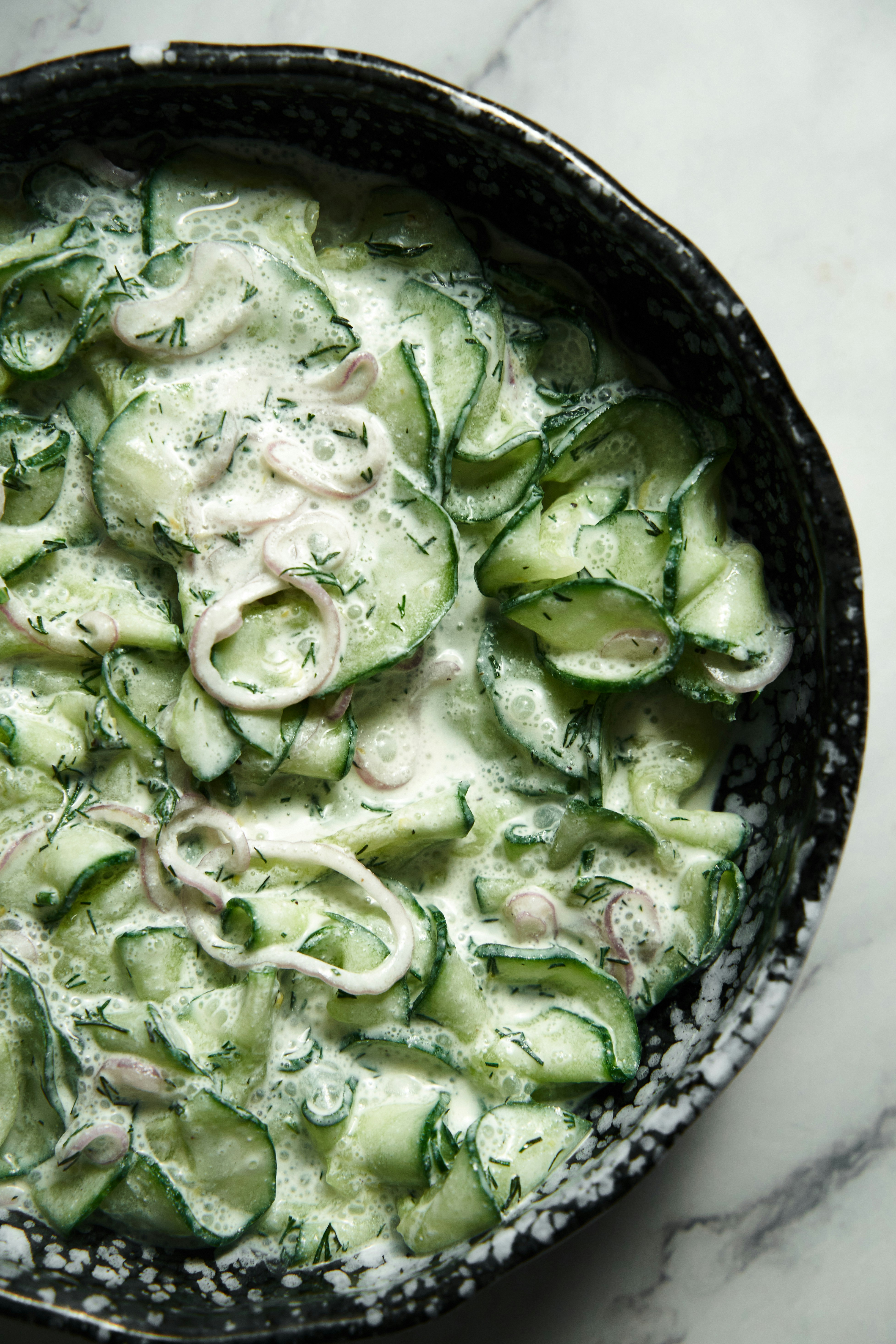 a bowl of cumcumbers and onions