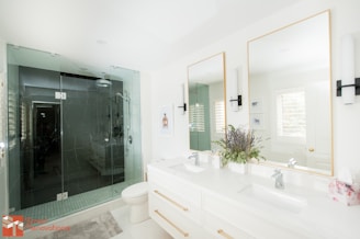 a bathroom with two sinks, a toilet and a shower