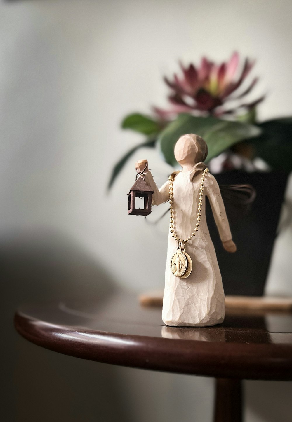 a figurine of a woman holding a lantern on a table