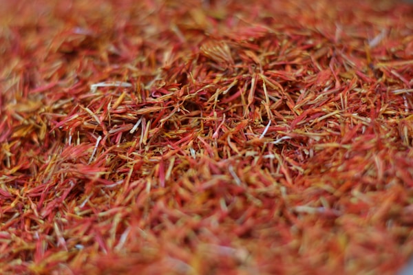 A close-up view of numerous dried saffron strands with a rich, vibrant red and orange hue.