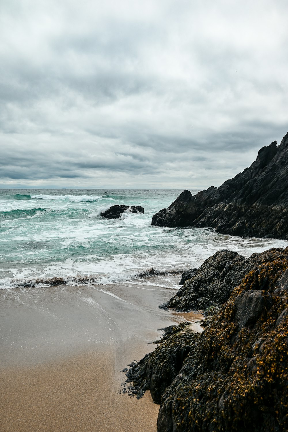 a sandy beach with waves coming in to shore