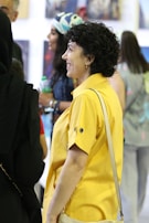 Group photo from an exhibition opening, showing joyful attendees and Juan Dona discussing his work.