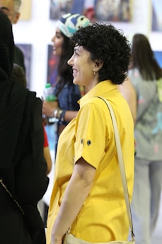 Photo of Juan Dona at an exhibition opening surrounded by community members.