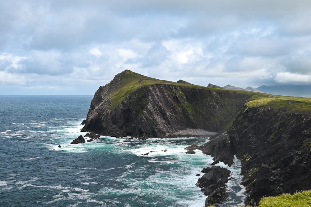 a large body of water sitting next to a lush green hillside