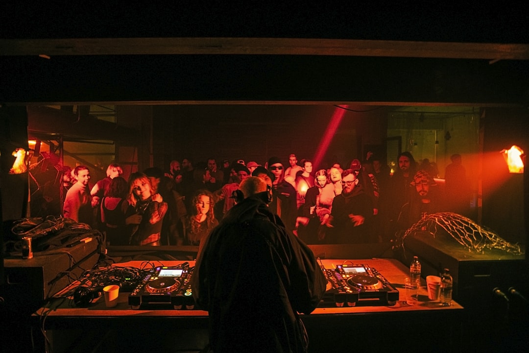 a dj in front of a large crowd of people,