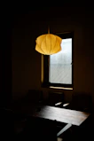 Close-up of a modern pendant light casting warm light over a dining table