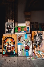 a number of paintings on a wall near one another