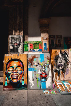 a number of paintings on a wall near one another