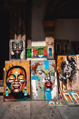 a number of paintings on a wall near one another