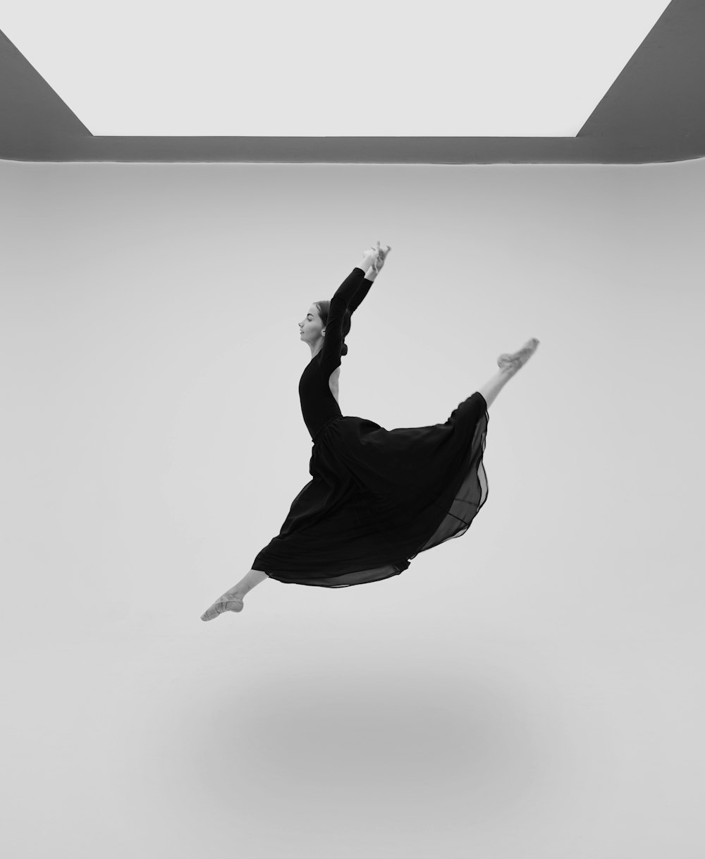 a woman in a black dress is flying through the air