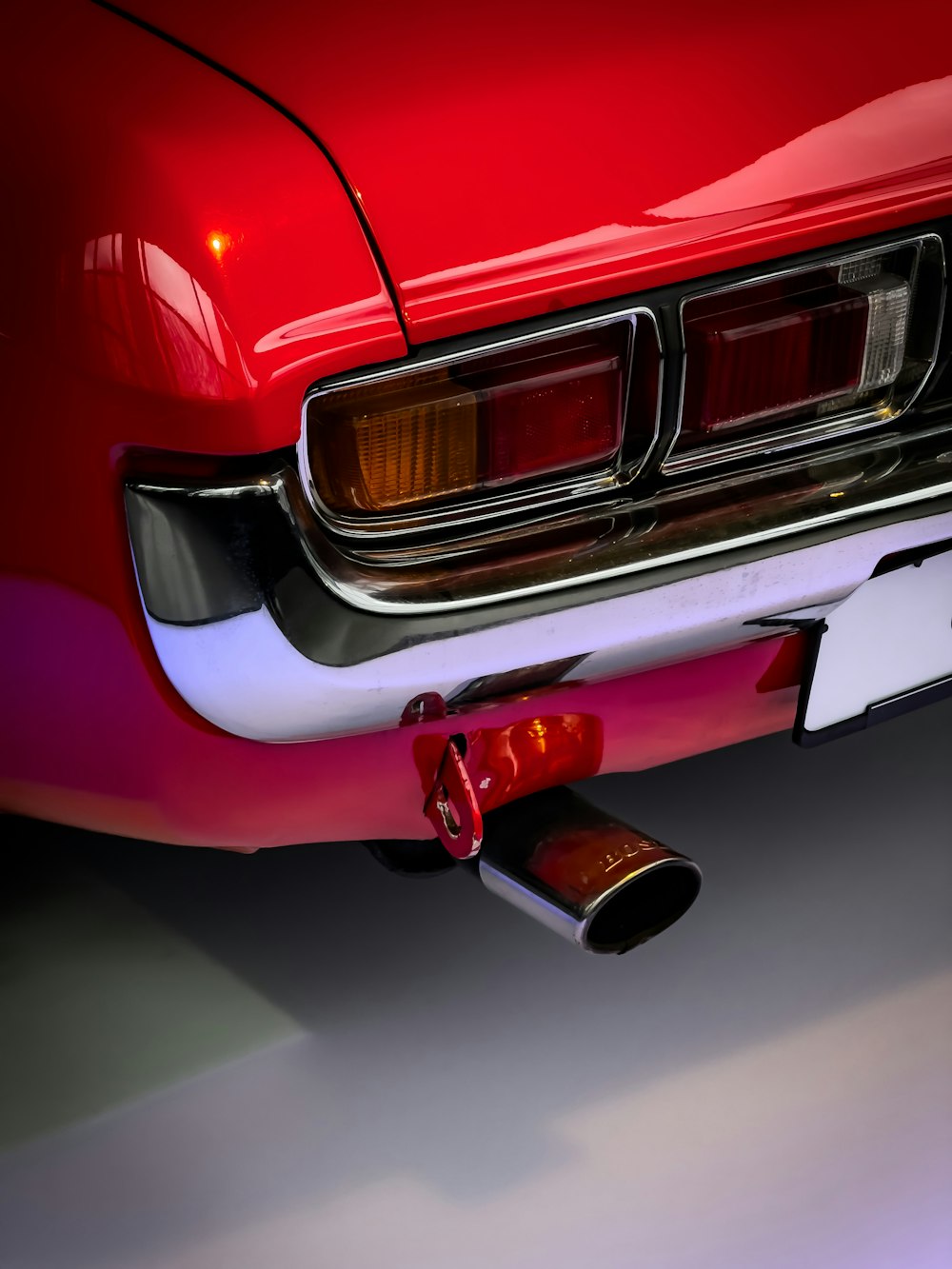 a close up of a red car with a exhaust pipe