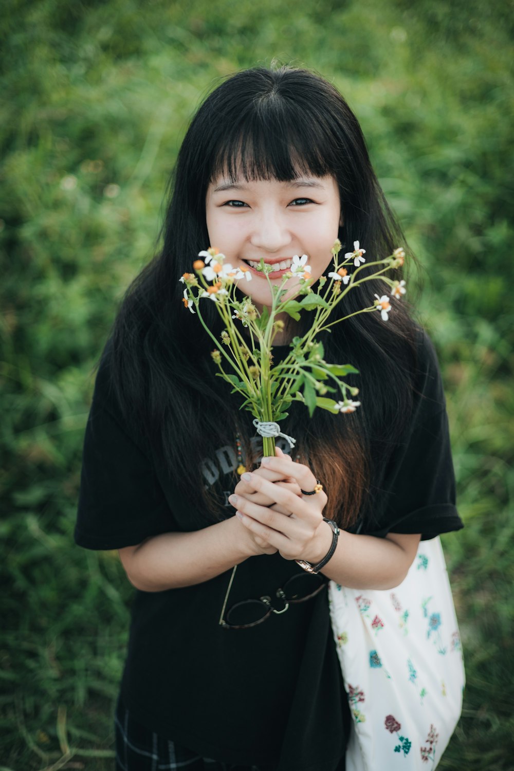 a woman holding a bunch of flowers in her hands