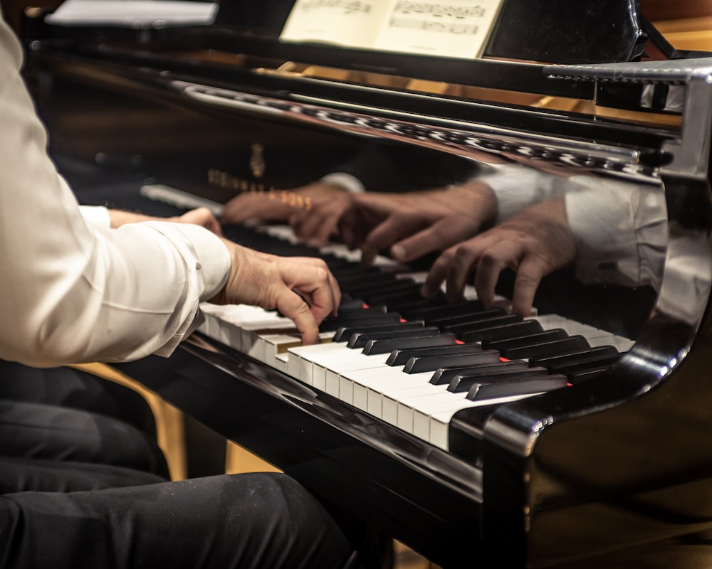 a man playing a piano while another man plays the piano