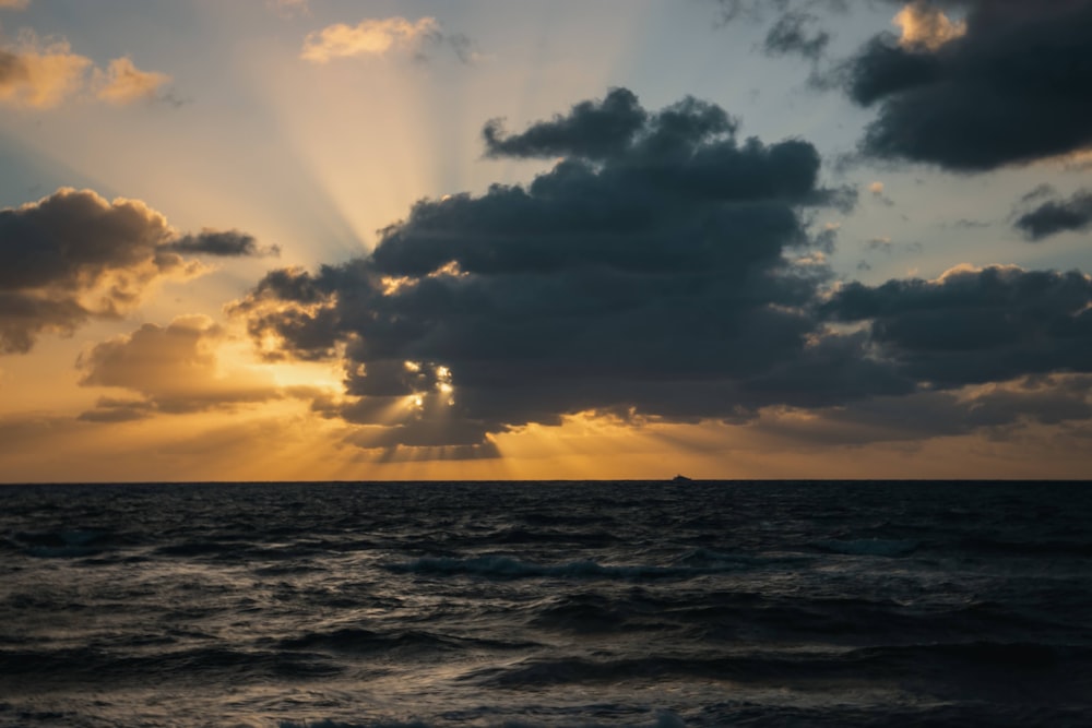 the sun is shining through the clouds over the ocean