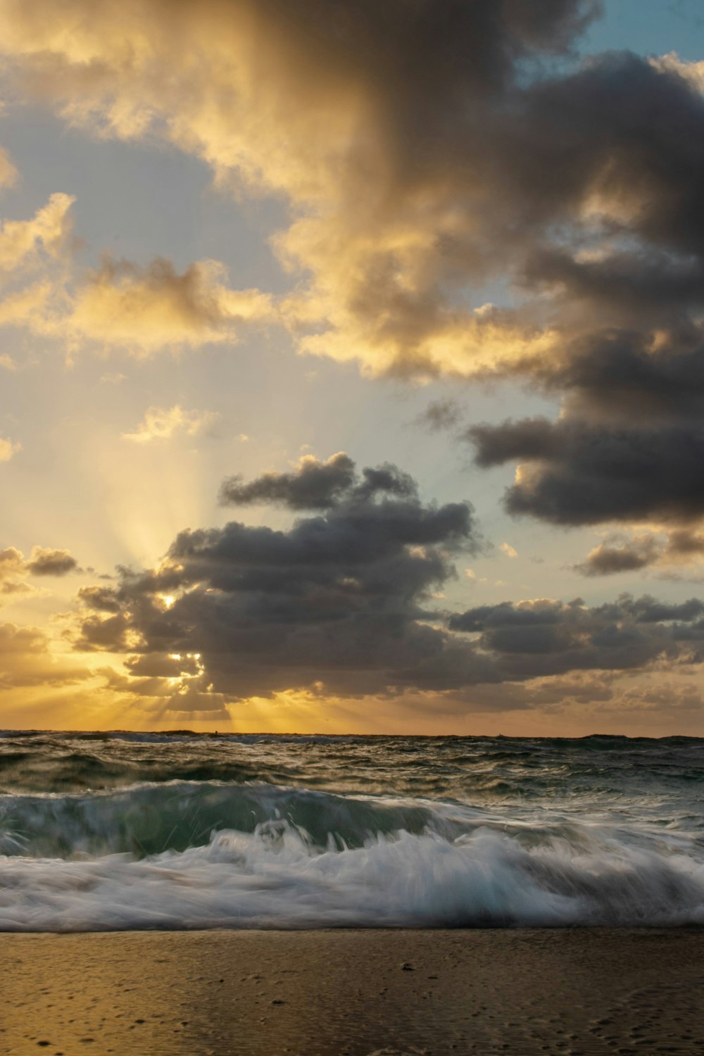 the sun is setting over the ocean waves