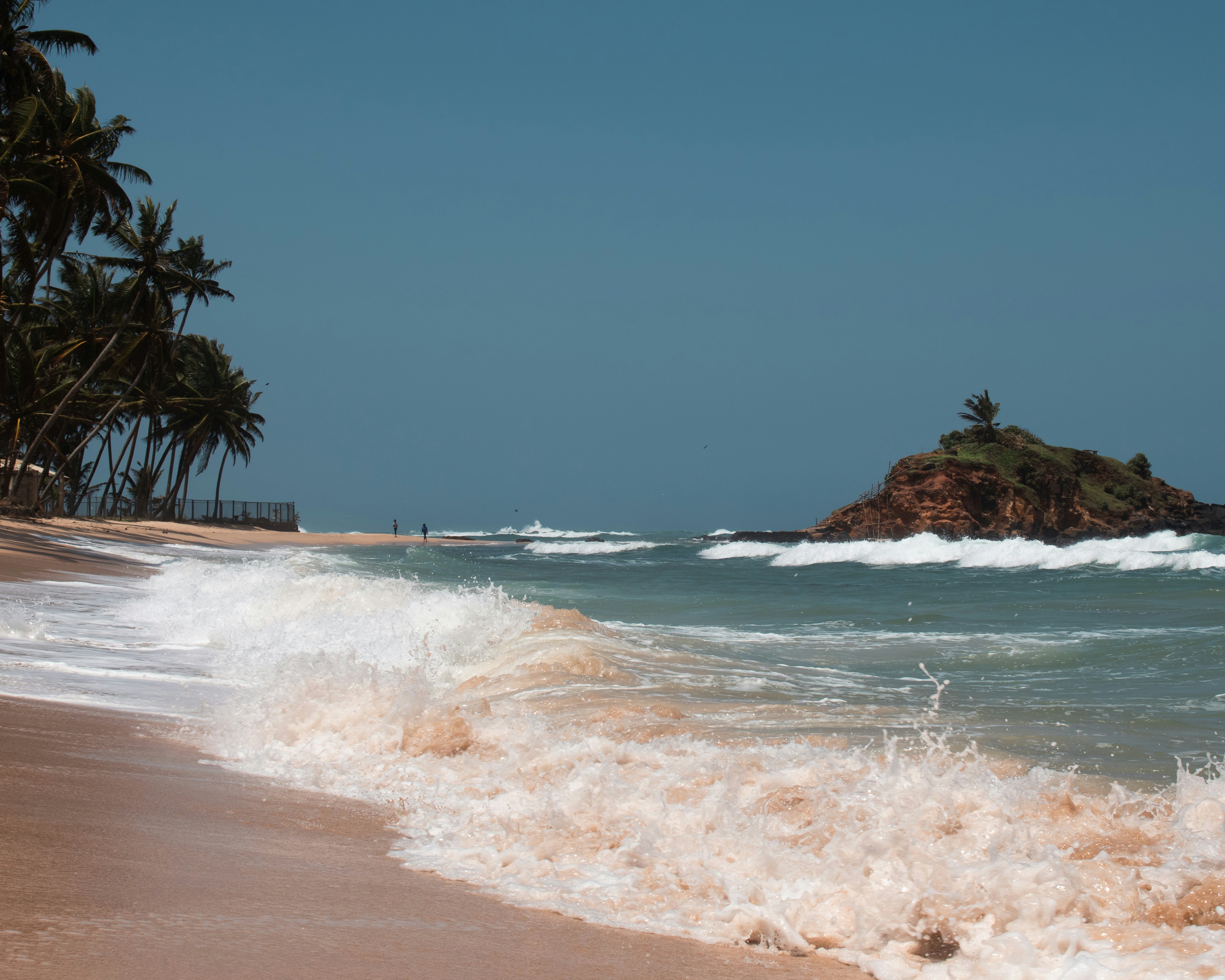 a sandy beach with waves coming in to shore