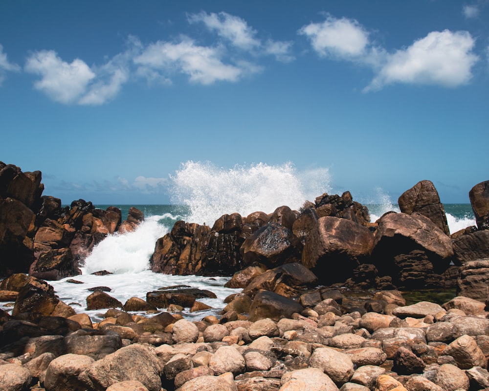 a rocky beach with waves crashing against the rocks