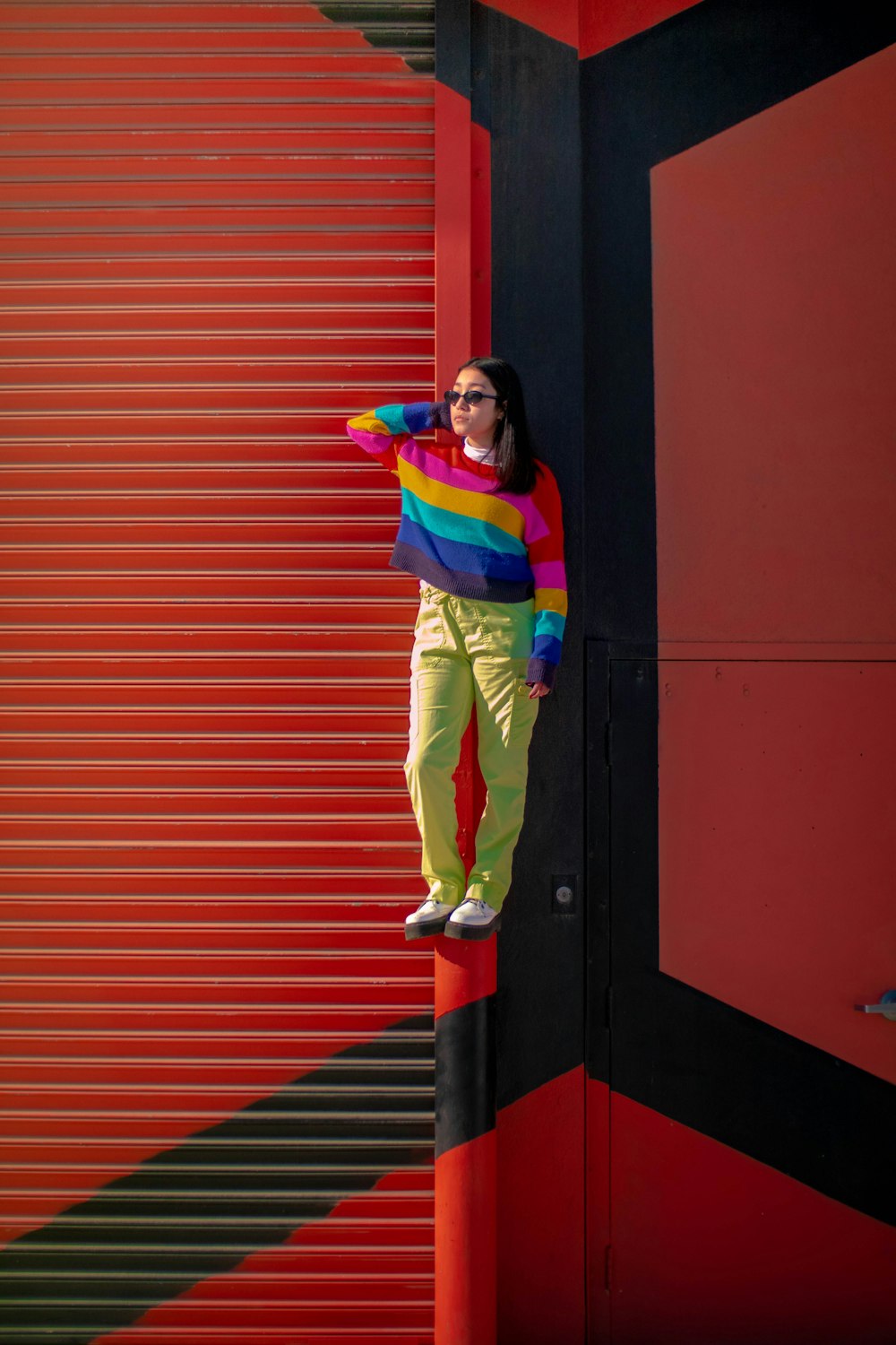 a woman standing on top of a red pole