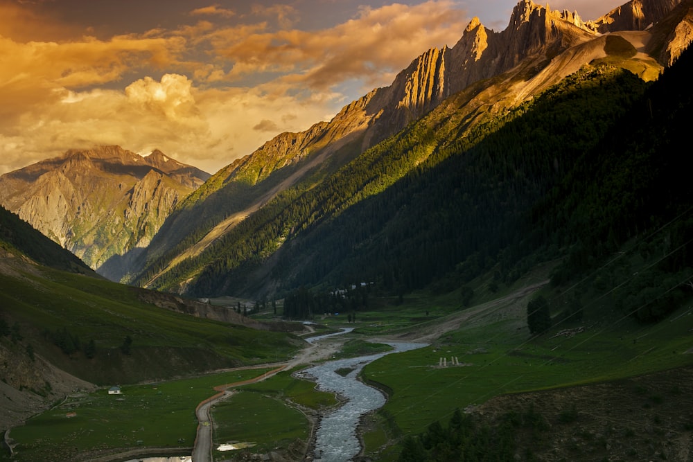 a river running through a valley surrounded by mountains