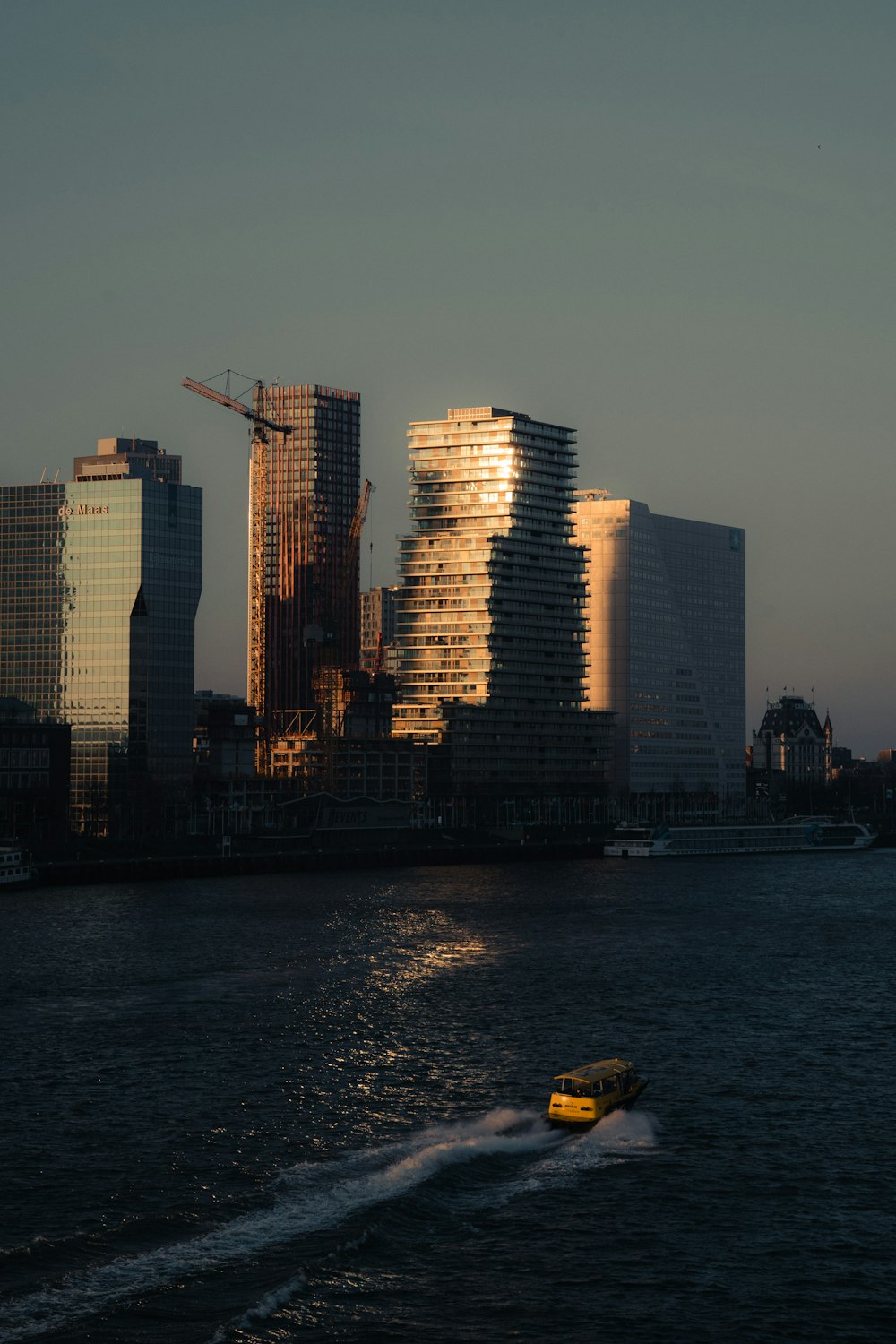 a boat traveling down a river next to tall buildings