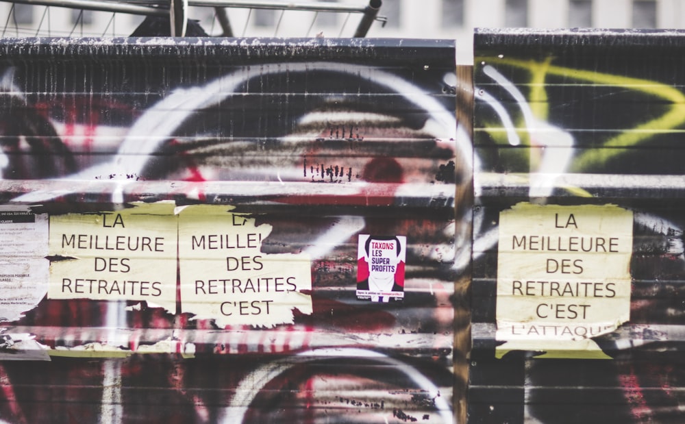 Ein Haufen Schilder an einer mit Graffiti bedeckten Wand